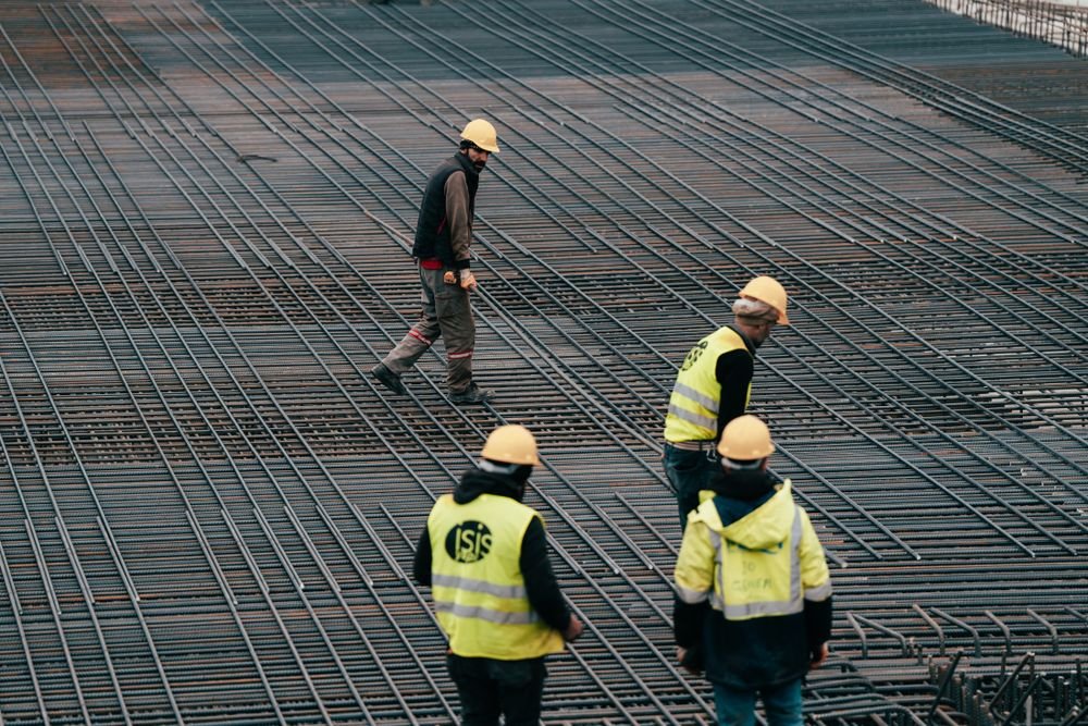 Workers building on a large TMT rebar reinforcement structure